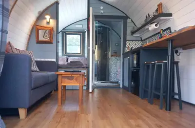 a living room with a couch and a table at Etive Pod, West Highland Way Holidays in Kinlochleven