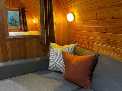 a couch in a wooden room with two pillows at Stoneymollan over Loch Lomond in Balloch