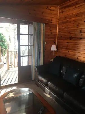 a living room with a leather couch and a glass table at Chalet in Tyndrum