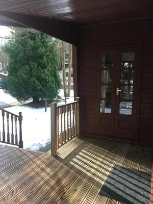 a porch with a door and a snow covered yard at Chalet in Tyndrum