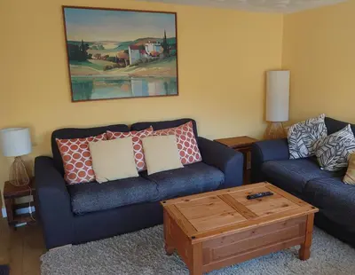 a living room with two couches and a coffee table at Arrochar Alps Apartment in Arrochar