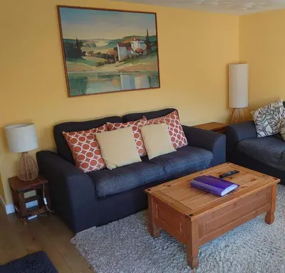 a living room with a couch and a coffee table at Arrochar Alps Apartment in Arrochar