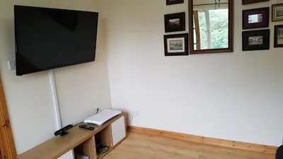 a flat screen tv hanging on a white wall at The Curling Pond, Dalmally Road, Inveraray in Inveraray