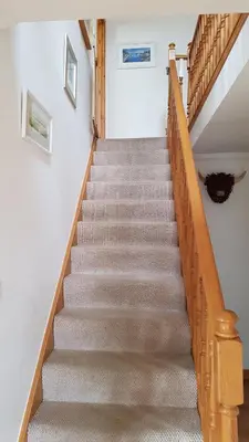 a staircase in a home with a wooden railing at The Curling Pond, Dalmally Road, Inveraray in Inveraray