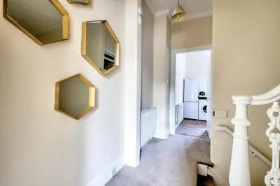 a hallway with two mirrors on the wall and a staircase at Oaktree Appartment Moffat in Moffat