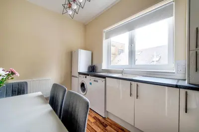 a kitchen with a sink and a refrigerator and a window at Oaktree Appartment Moffat in Moffat