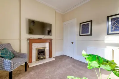 a living room with a fireplace and a tv at Oaktree Appartment Moffat in Moffat