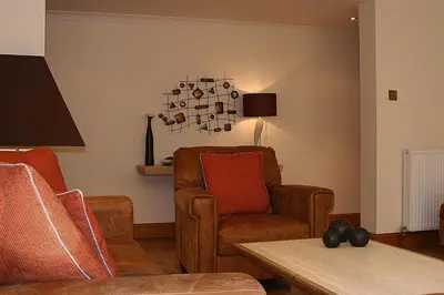 a living room with a couch and a chair at Kingsview Apartment in Stirling