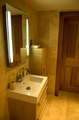 a bathroom with a sink and a mirror at Kingsview Apartment in Stirling