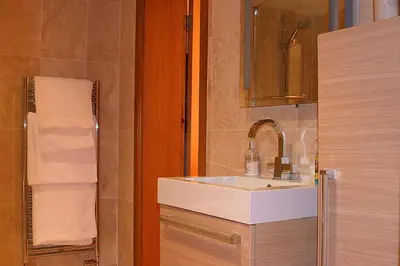 a bathroom with a white sink and a mirror at Kingsview Apartment in Stirling