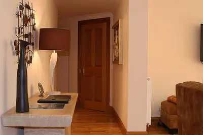 a living room with a table with a lamp and a door at Kingsview Apartment in Stirling
