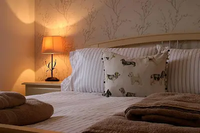 a bedroom with a bed with white sheets and pillows at Linden Apartment in Stirling