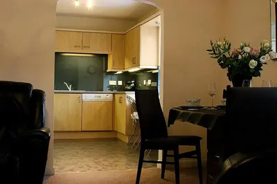 a kitchen with a table and a dining room at Linden Apartment in Stirling