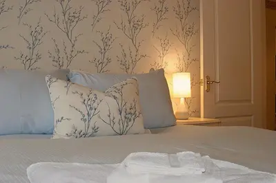 a bedroom with a bed with blue and white wallpaper at Linden Apartment in Stirling