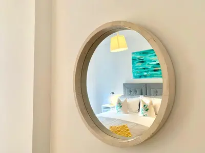 a mirror on a wall with a bed in a room at Hillington Central in Glasgow