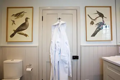 a bathroom with a robe hanging next to a door at Ross Lodge in Comrie