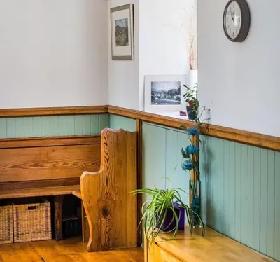 a room with a bench and a clock on the wall at Eastkirk in Corrie