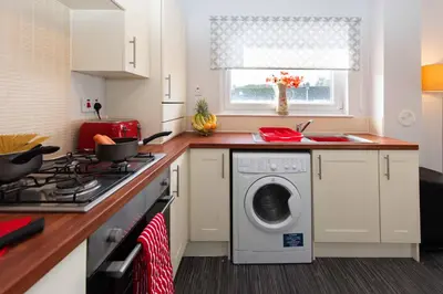 a kitchen with a washing machine and a sink at PREMIER - Wishaw En-Suite Apartment in Wishaw
