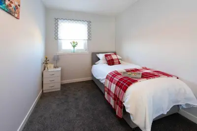 a small bedroom with a bed and a window at PREMIER - Wishaw En-Suite Apartment in Wishaw
