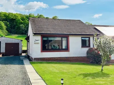 a white house with a window and a yard at The Hoolit in Crieff