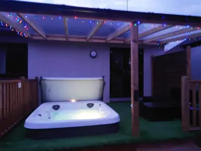 a hot tub in the middle of a patio with lights at The Hoolit in Crieff