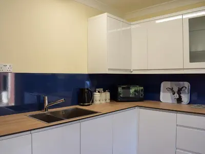 a kitchen with white cabinets and a sink at The Hoolit in Crieff