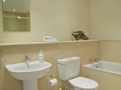 a bathroom with a toilet and a sink and a tub at The Bothy in Stron-fearnan