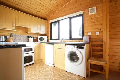 a kitchen with a washing machine and a washer at Concraig Lodge in Crieff