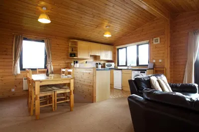 a kitchen and dining room with a table in a cabin at Concraig Lodge in Crieff