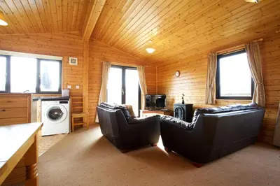 a living room with two leather chairs in a cabin at Concraig Lodge in Crieff