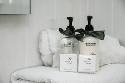 two bottles of soap sitting on top of a towel at Rowan Tree Apartment - Modern Apartment, Free Parking & Views in Oban