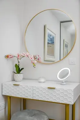 a bathroom with a white vanity with a round mirror at Rowan Tree Apartment - Modern Apartment, Free Parking & Views in Oban