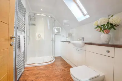a bathroom with a shower and a toilet and a sink at Rowan Tree Apartment - Modern Apartment, Free Parking & Views in Oban