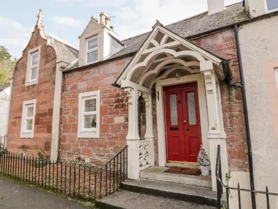 an old brick house with a red door at Ivy Bank in Thornhill