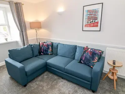 a blue couch in a living room with a table at Ivy Bank in Thornhill
