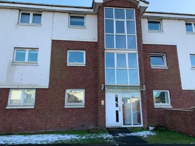 an empty brick building with a white door at Flat One, 212 Eaglesham Road, East Kilbride, Glasgow in Glasgow