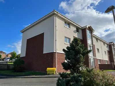 a brick building with a large door on the side of it at Flat One, 212 Eaglesham Road, East Kilbride, Glasgow in Glasgow