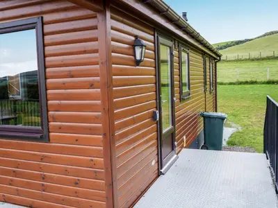 a wooden cabin with a door and a window at Chalet Osprey Lodge by Interhome in Kinross
