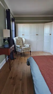 a bedroom with a bed and a chair and a desk at Beautiful self contained apartment with garden in Glasgow