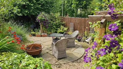 a garden with a table and chairs and flowers at Beautiful self contained apartment with garden in Glasgow
