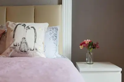 a bed with a pillow and a vase of flowers at Stunning 2-Bed Apartment in Central Edinburgh in Edinburgh