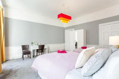 a bedroom with two beds and a desk in it at Stunning 2-Bed Apartment in Central Edinburgh in Edinburgh