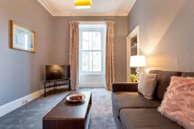 a living room with a couch and a tv at Stunning 2-Bed Apartment in Central Edinburgh in Edinburgh