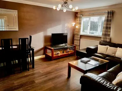 a living room with a couch and a table at Levenview Holiday Apartment Loch Lom in Balloch