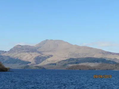 a mountain in the middle of a large body of water at Levenview Holiday Apartment Loch Lom in Balloch