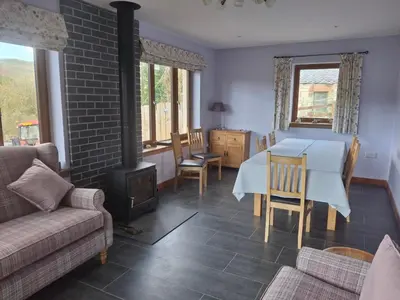 a living room with a table and a stove at Rockfoot B&B in Fintry