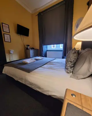 a hotel room with a large bed and a window at Stay - Gilmore Guesthouse in Edinburgh