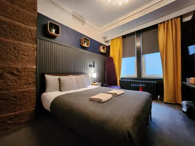 a bedroom with a large bed with two towels on it at Frederick Douglass - Rooms In The City in Edinburgh