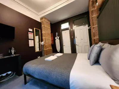 a bedroom with a bed with two towels on it at Frederick Douglass - Rooms In The City in Edinburgh