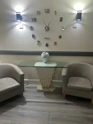 a table and two chairs and a clock on the wall at Dellwood Hotel in Campbeltown